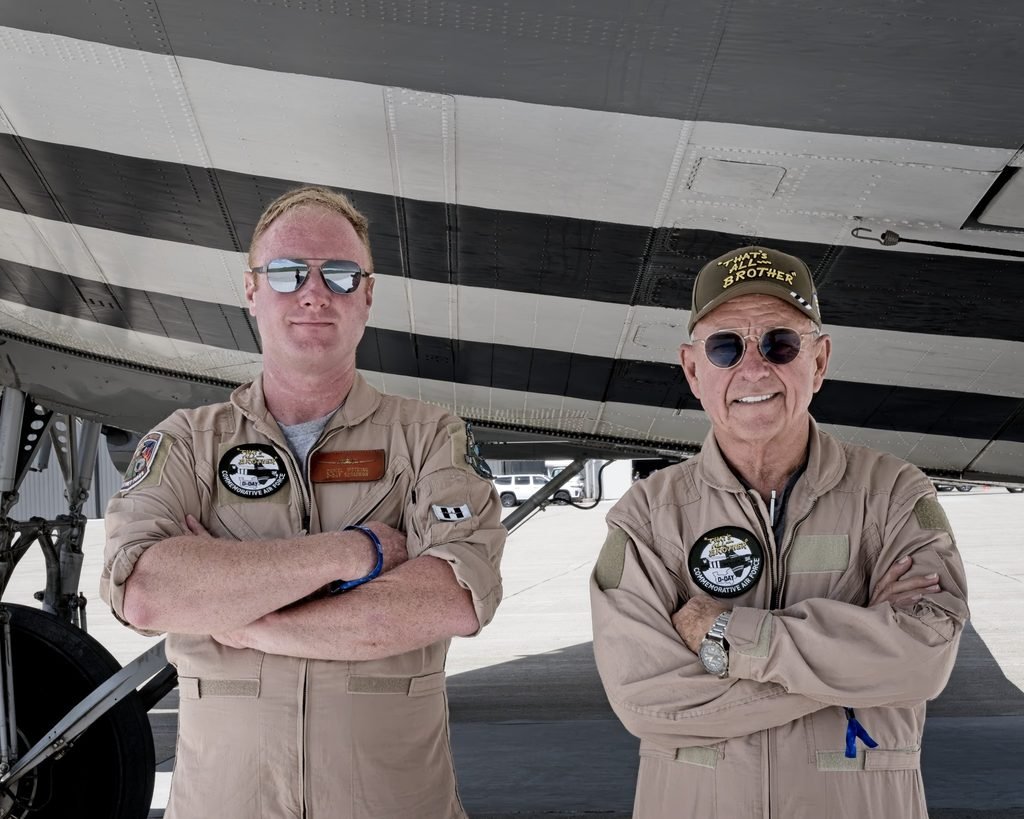 Daniel Wotring, left, and Larry Lumpkin standing together beneath the wing of the C-47 That’s All, Brother.